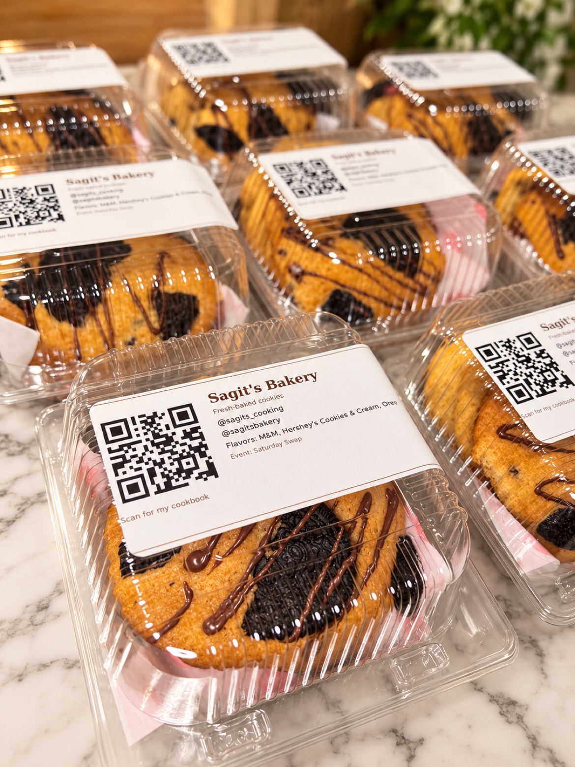 Individually packaged cookies in clear containers with Sagit's Bakery labels, ready for a gathering